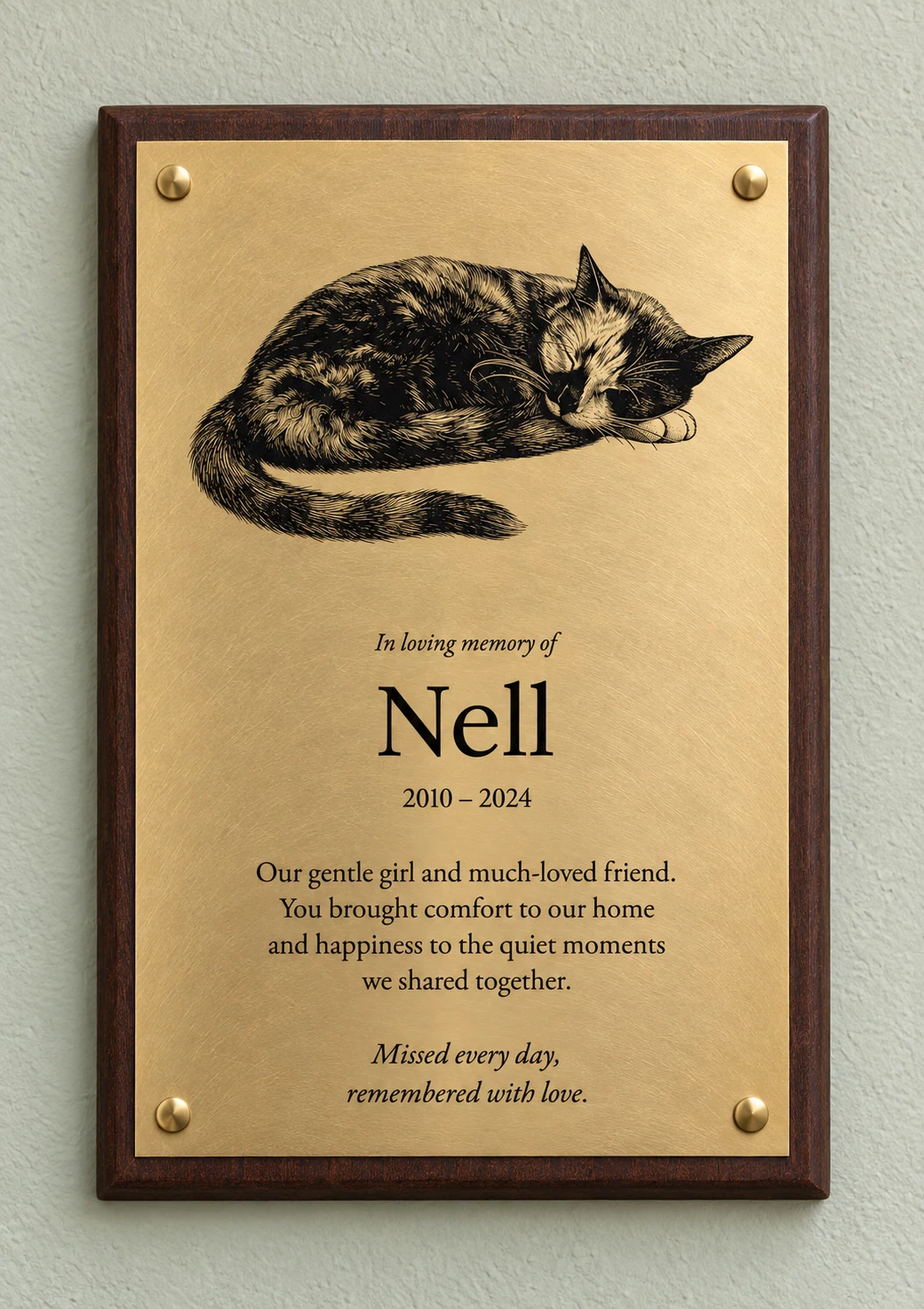 Full sleeping-cat portrait of Nell above a memorial inscription on orbital brass, with a bevelled mahogany board and brass screw caps